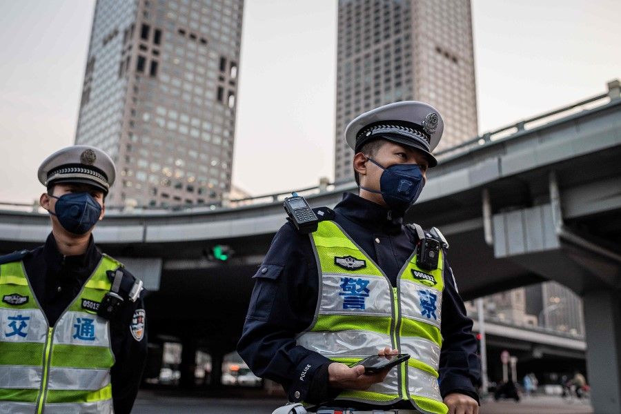 Police officers at a street crossing in Beijing, April 7, 2020. Control measures in Beijing have not been relaxed yet. (Nicolas Asfouri/AFP)