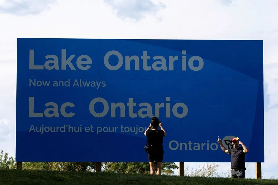 People take photos in front of a sign reading "Lake Ontario, Now and Always", unveiled by Ontario Premier Doug Ford at Fifty Point Conservation Area, after US President Donald Trump signed an executive order renaming Lake Ontario as "Lake America", near Grimsby, Ontario, Canada, 29 August 2026.