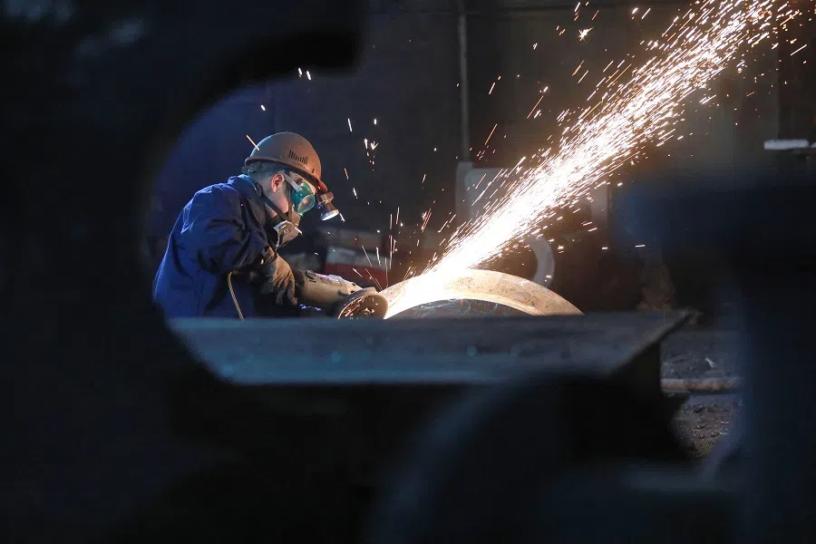 A worker grinds a piece of equipment in a workshop in Hangzhou, in China’s eastern Zhejiang province on 14 February 2025. (AFP)