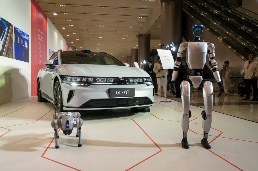 A Zeekr 007 GT electric vehicle, Unitree Robotics G1 humanoid robot, and Go2 robot dog during a launch event in Hangzhou, China, on 18 March 2025. (Raul Ariano/Bloomberg)