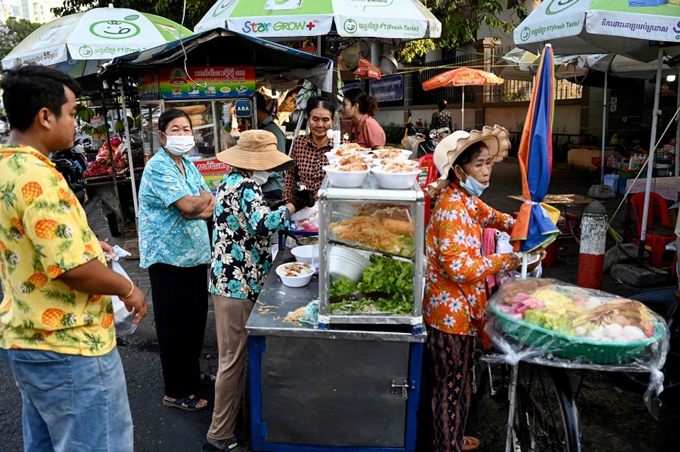 People buy food along a street in Phnom Penh, Cambodia, on 11 March 2025. (Tang Chhin Sothy/AFP)