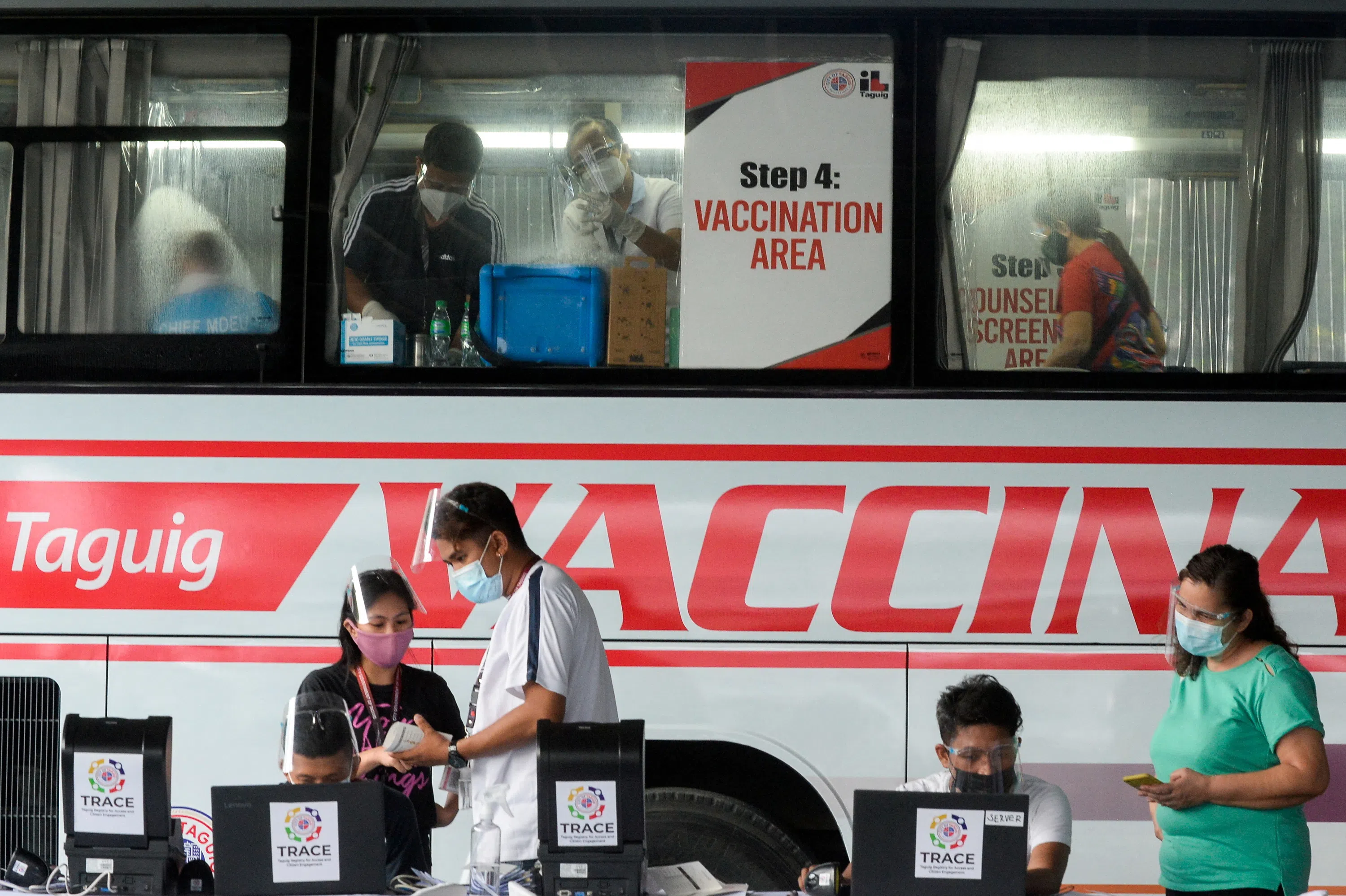 Health workers encode information and prepare vaccines against the coronavirus (Covid-19) at a mobile vaccination site in Taguig, Metro Manila, Philippines, on 21 May 2021. 
