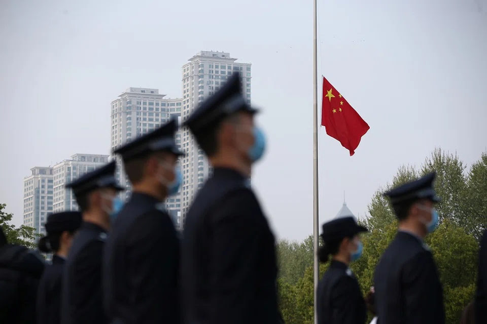 The Chinese national flag flies at half mast at a ceremony mourning those who died of the Covid-19 coronavirus as China holds a nationwide mourning on the Qingming Festival, in Wuhan, China, on 4 April 2020. (China Daily via Reuters)
