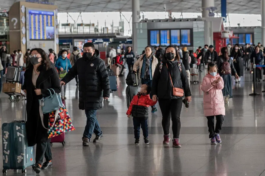 Travellers wearing masks at Beijing Capital International Airport, 22 January 2020. (Nicolas Asfouri/AFP)