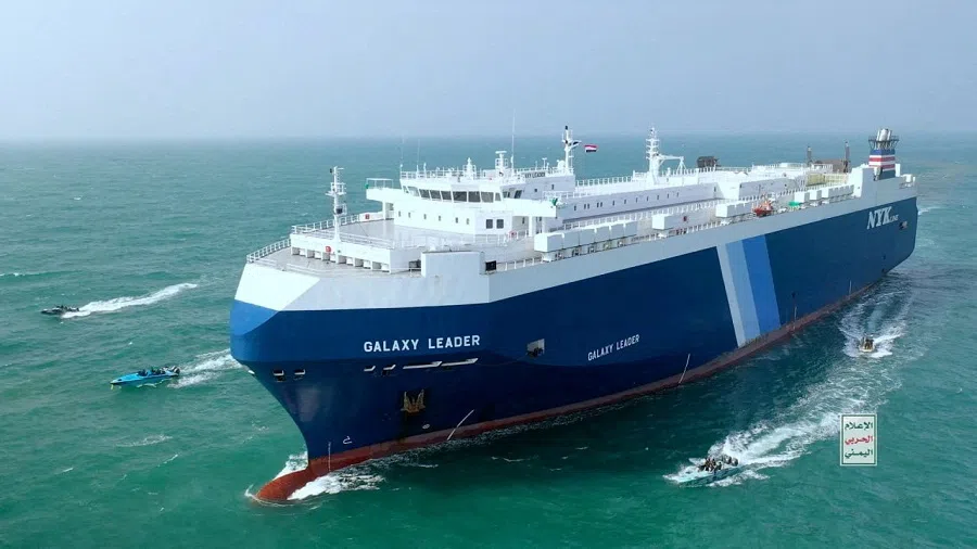 The Galaxy Leader cargo ship is escorted by Houthi boats in the Red Sea in this photo released 20 November 2023. (Houthi Military Media/Handout via Reuters)