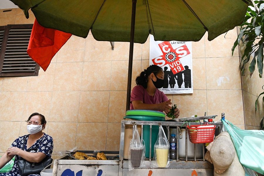 A Vietnamese vendor sells food in the old quarters of Hanoi on 29 April 2020. (Manan Vatsyayana/AFP)
