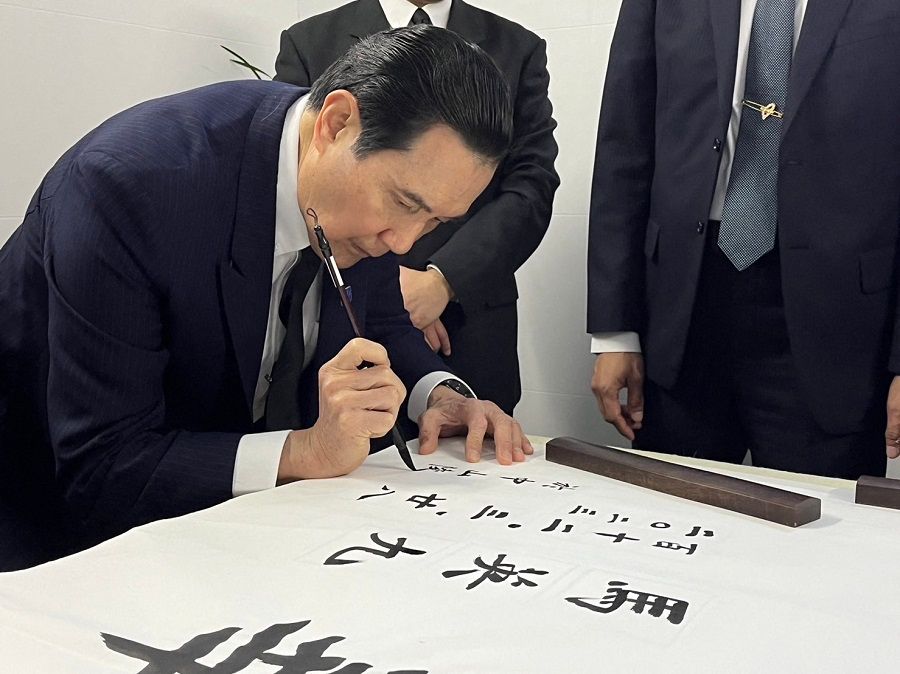 This handout picture taken and released by the office of former Taiwanese president Ma Ying-jeou on 28 March 2023 shows former Taiwanese President Ma Ying-jeou using a brush to write calligraphy at Dr. Sun Yat-sen's Mausoleum in Nanjing, in China's eastern Jiangsu province. (Handout/Ma Ying-jeou's office/AFP)
