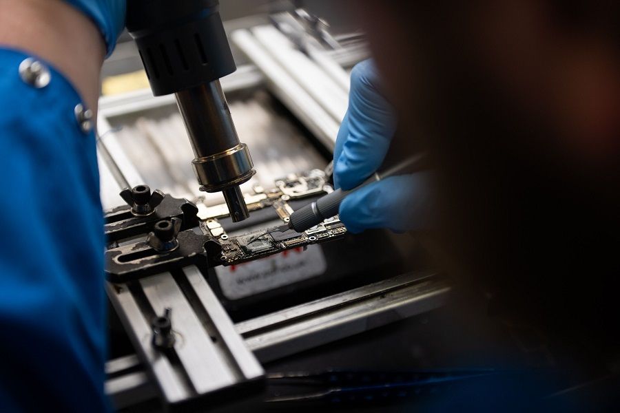 A specialist removes a Kirin 9000s chip fabricated in China by Semiconductor Manufacturing International Corp (SMIC) from a Huawei Mate 60 Pro smartphone in Ottawa, Ontario, Canada, on 3 September 2023. (James Park/Bloomberg)