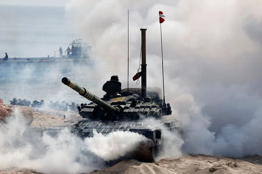 Soldiers move past a T-72 tank as they participate in a tri-services military drill in Porbandar in the western state of Gujarat, India, on 13 November 2025. The exercise was part of military drills conducted by the Indian Army, Navy and Air Force under the tri-services framework of Exercise Trishul. (Amit Dave/Reuters)