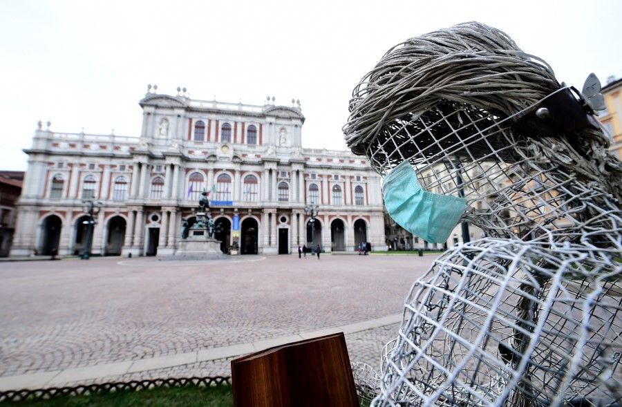 A face mask is attached to the sculpture at the Carlo Alberto Square, in Turin, Italy. (Massimo Pinca/REUTERS)