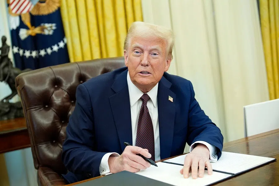 US President Donald Trump signs an executive order in the Oval Office of the White House in Washington, DC, US, on 23 January 2025.