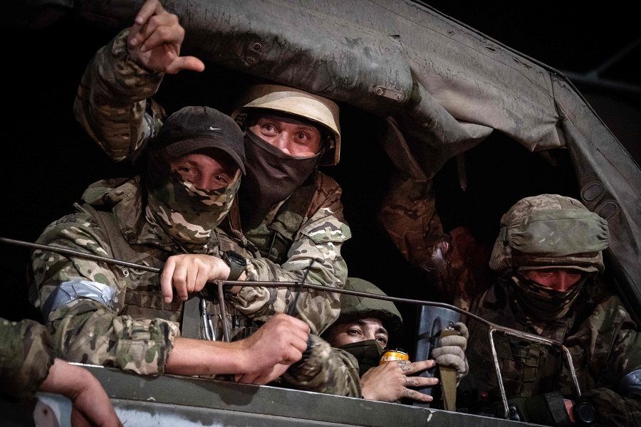 Members of Wagner Group look from a military vehicle in Rostov-on-Don late on 24 June 2023. (Roman Romokhov/AFP)