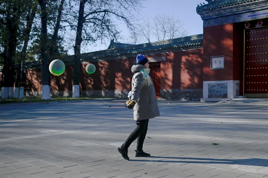 A woman uses balls to exercise at a park in Beijing on 30 November 2023. (Wang Zhao/AFP)