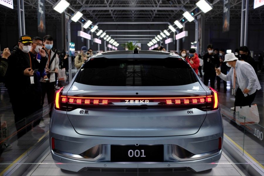 Visitors check a Zeekr 001, a model from Geely's new premium electric vehicle (EV) brand Zeekr, at its factory in Ningbo, Zhejiang province, China, 15 April 2021. (Yilei Sun/Reuters)