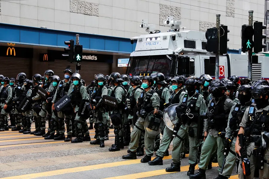 A row of riot police officers is seen in front of a water cannon vehicle during a march against the national security law in Hong Kong, China, on 1 July 2020. (Tyrone Siu/Reuters)