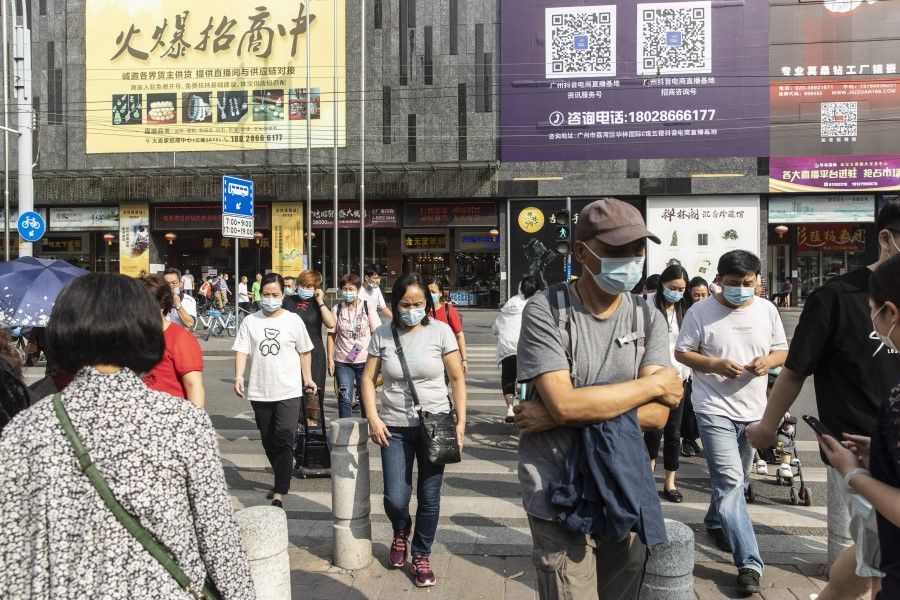 Pedestrians walk across a road in the Shangxiajiu shopping district in Guangzhou, China, on 19 November 2020.(Qilai Shen/Bloomberg)