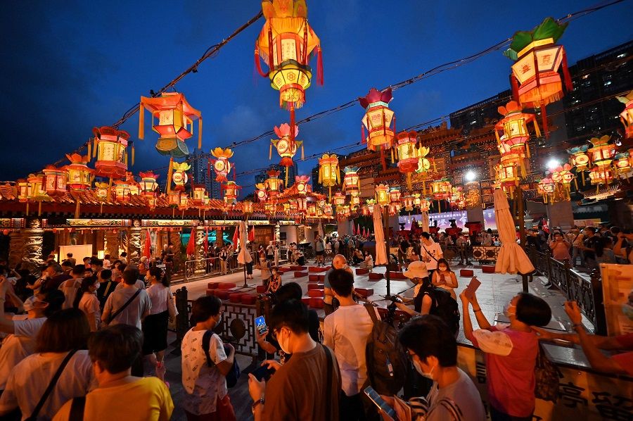 Visitors walk through a display of lanterns ahead of the mid-autumn festival at Wong Tai Sin temple in Hong Kong on 18 September 2021. (Peter Parks/AFP)