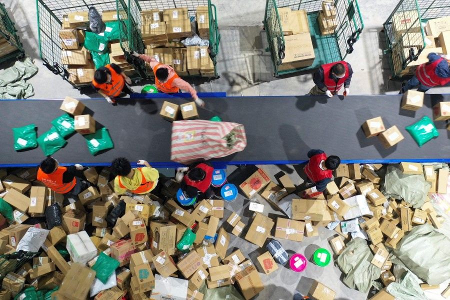 Workers sort packages for delivery at a warehouse of China Post Group in Hengyang, in central China's Hunan province on 12 November 2020, a day after the end of the Singles' Day shopping festival. (STR/AFP)