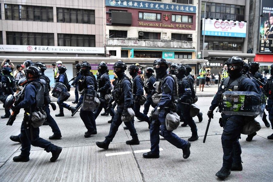 Riot police march down a street as they take action to disperse protesters taking part in a pro-democracy rally against a proposed new security law in Hong Kong, 24 May 2020. (Anthony Wallace/AFP)