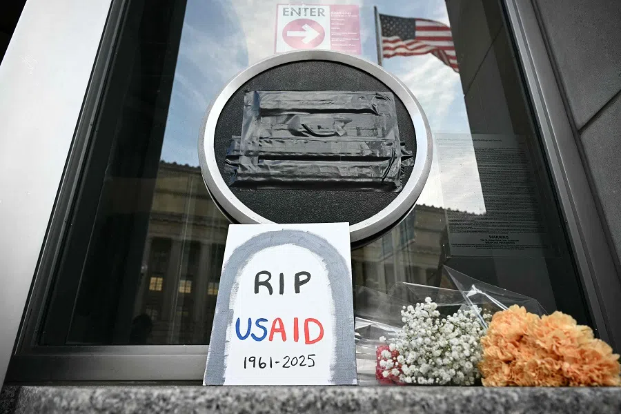 Tributes are placed beneath the covered seal of the US Agency for International Development (USAID) at their headquarters in Washington, DC, on 7 February 2025.