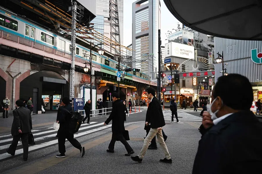 People walk near Shimbashi station in Tokyo on 20 November 2025.