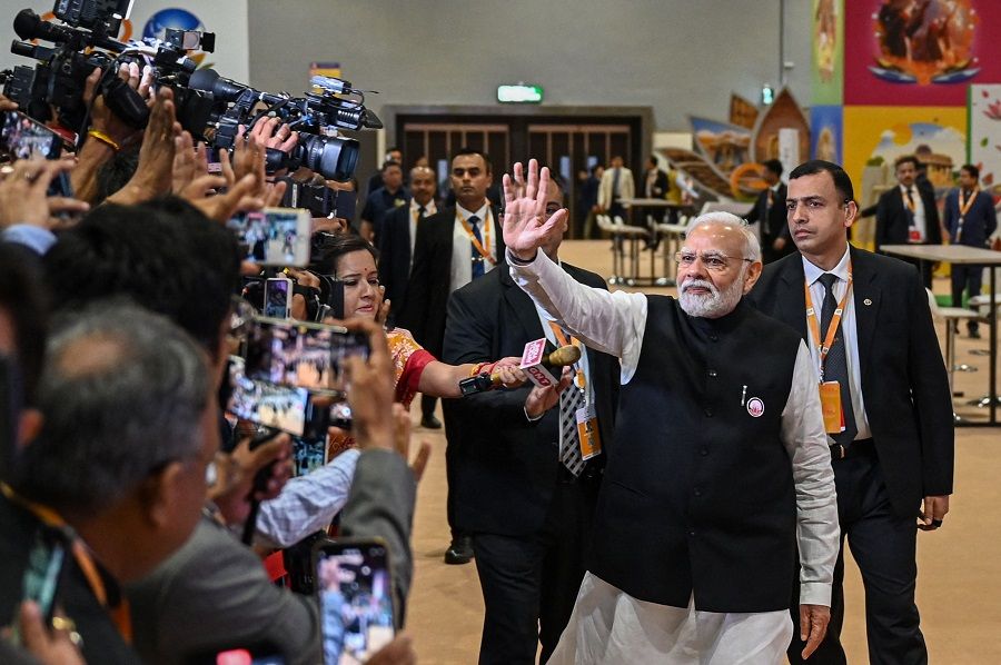 India's Prime Minister Narendra Modi (centre) waves to media representatives during his visit to the International Media Centre, at the G20 summit venue, in New Delhi, India on 10 September 2023. (Money Sharma/AFP)