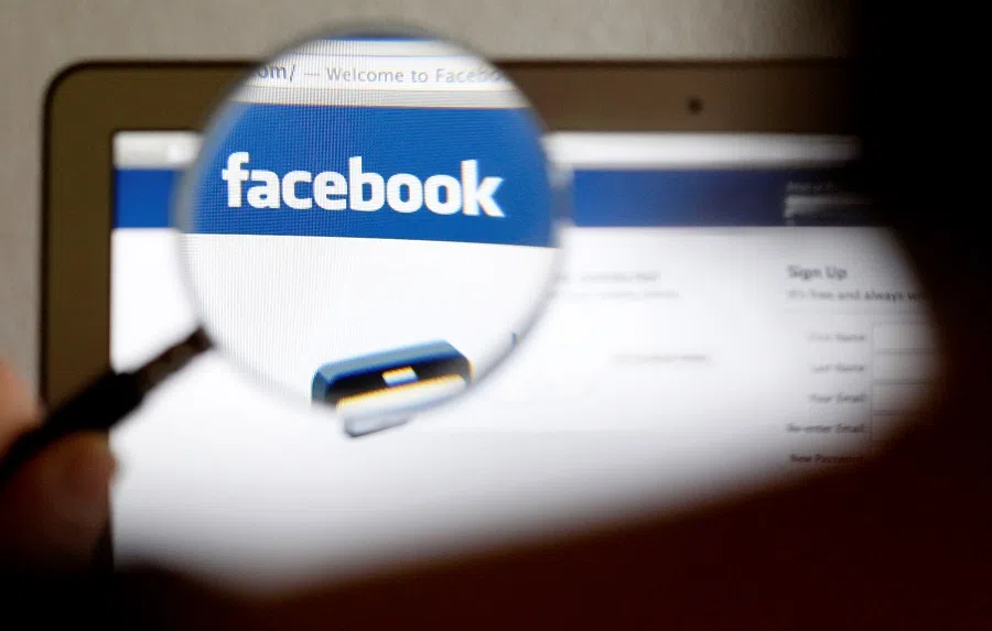 In this photo illustration, a Facebook logo on a computer screen is seen through a magnifying glass in Bern, Switzerland, 19 May 2012. (Thomas Hodel/File Photo/Reuters)