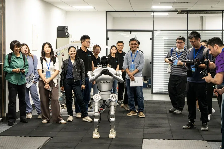 Employees control a humanoid robot during a demonstration for members of the media at the Shandong Youbaote Intelligent Robot Co. offices in Jinan, Shandong province, China, on 17 September 2025. (Qilai Shen/Bloomberg)