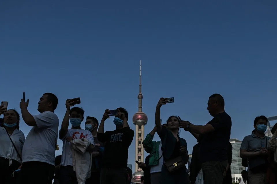 People visit the promenade on the Bund along the Huangpu River during a Labour Day holiday in Shanghai on 1 May 2021. (Hector Retamal/AFP)