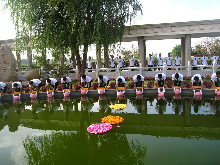 Attendants carrying biodegradable urns in a procession for a collective eco-funeral at Yong’an cemetery on 20 July 2010. (SPH Media)