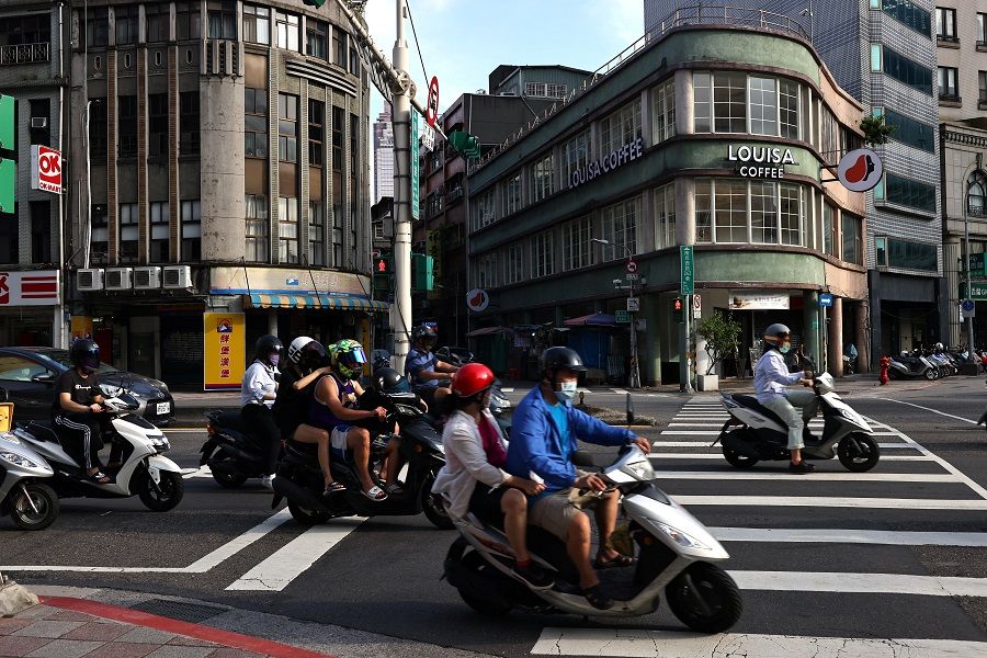 People wearing protective face masks drive motorbikes in Taipei, Taiwan, 30 June 2021. (Ann Wang/Reuters)