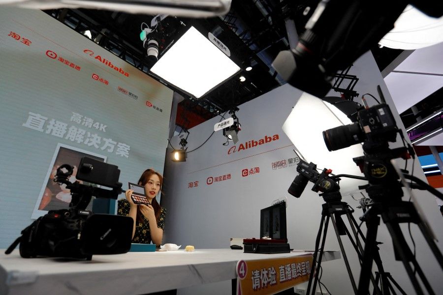 A woman demonstrates a camera, lighting and display setup for live-streaming at the Alibaba booth at the China International Fair for Trade in Services (CIFTIS) in Beijing, China, 1 September 2022. (Florence Lo/Reuters)