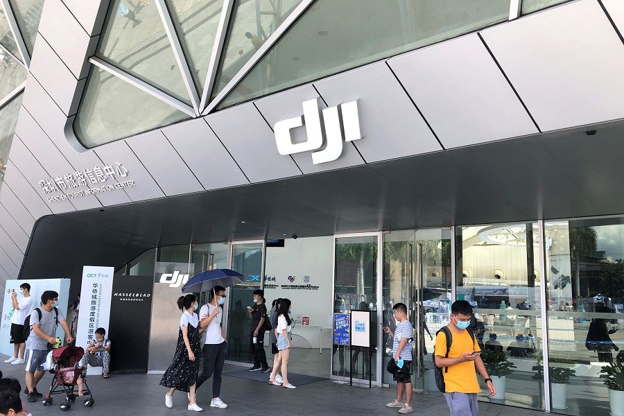 People wearing face masks following the Covid-19 outbreak walk past DJI's flagship store in Shenzhen, Guangdong, China, 8 August 2020. (David Kirton/Reuters)
