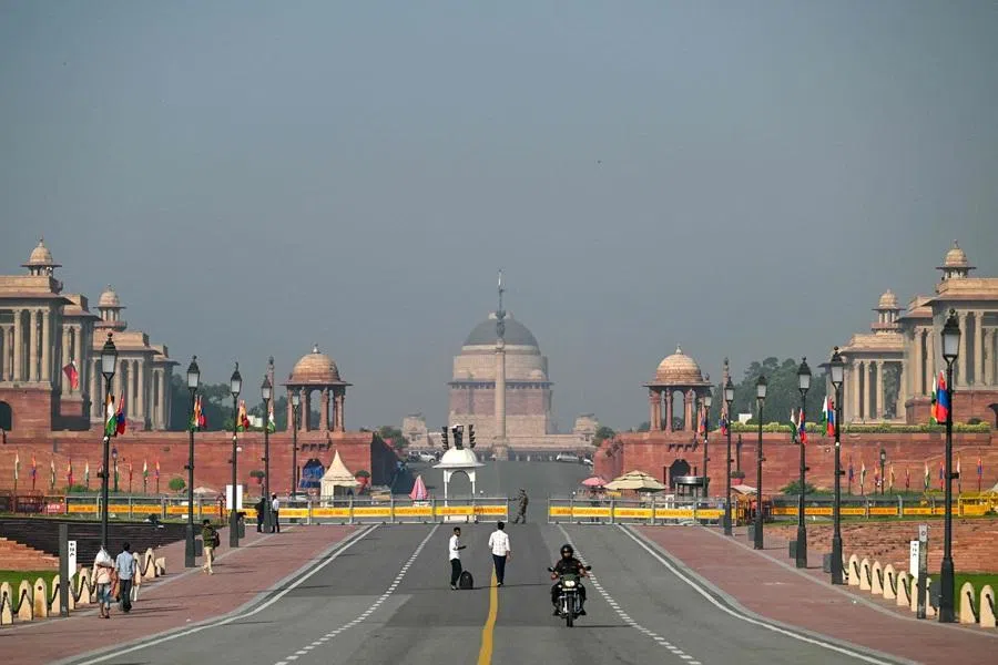 People walk past Kartavya Path near India’s presidential palace, Rashtrapati Bhavan, in New Delhi on 14 October 2025. (Arun Sakar/AFP)