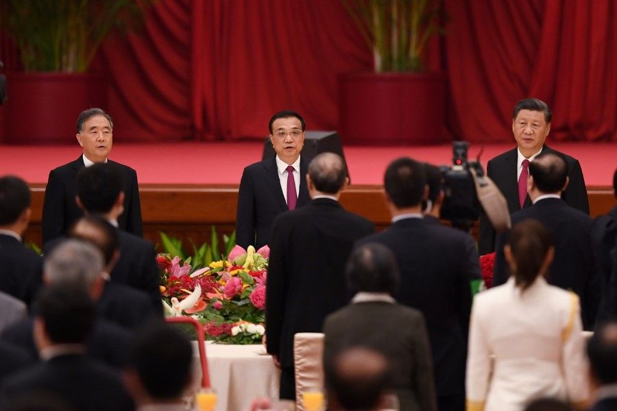 Chinese President Xi Jinping (R), Premier Li Keqiang (C) and Politburo Standing Committee member Wang Yang (L) sing the national anthem during a reception at the Great Hall of the People on the eve of China's National Day on 30 September 2020. (Greg Baker/AFP)