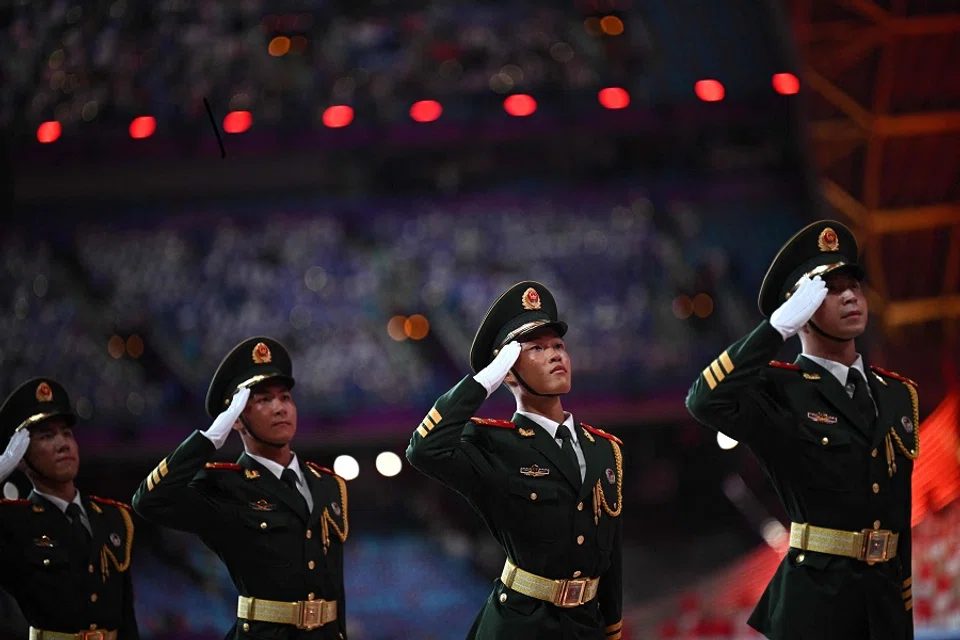 Chinese military personnel salute as China's national flag is hoisted during the opening ceremony of the 2022 Asian Games at the Hangzhou Olympic Sports Centre Stadium in Hangzhou in China's eastern Zhejiang province on 23 September 2023. (Philip Fong/AFP)