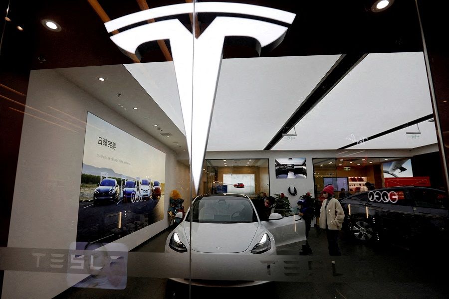 Visitors check a Tesla Model 3 car next to a Model Y displayed at a showroom of the US electric vehicle (EV) maker in Beijing, China, 4 February 2023. (Florence Lo/File Photo/Reuters)