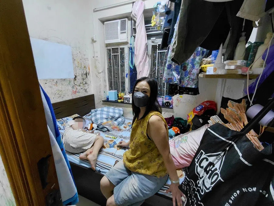 Madam Wang’s daughter and her family of three live in an 80 square foot subdivided unit in Sham Shui Po, Hong Kong. The photo shows Madam Wang taking care of her grandson in her daughter’s rented flat. (Tai Hing Shing/SPH Media)