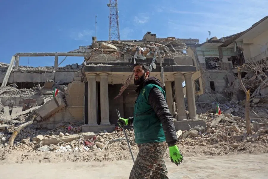 A man walks past destroyed buildings following airstrikes in central Tehran on 4 March 2026.