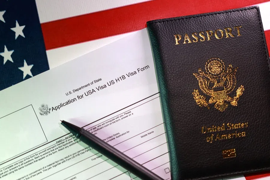 A US flag, a passport and a US H-1B Visa application form are seen in this illustration taken on 22 September 2025. (Dado Ruvic/Illustration/Reuters)