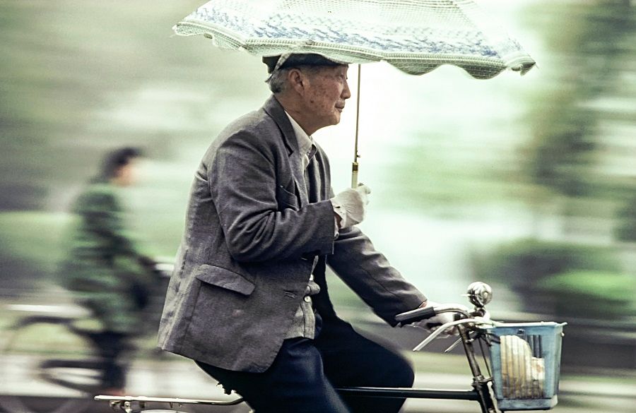 An old man rides his bicycle on a street in Beijing, China, 1982. (iStock)