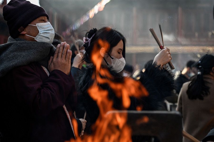 People gather to burn incense sticks and offer prayers at the Lama Temple, in Beijing, China, on 19 February 2023. (Jade Gao/AFP)