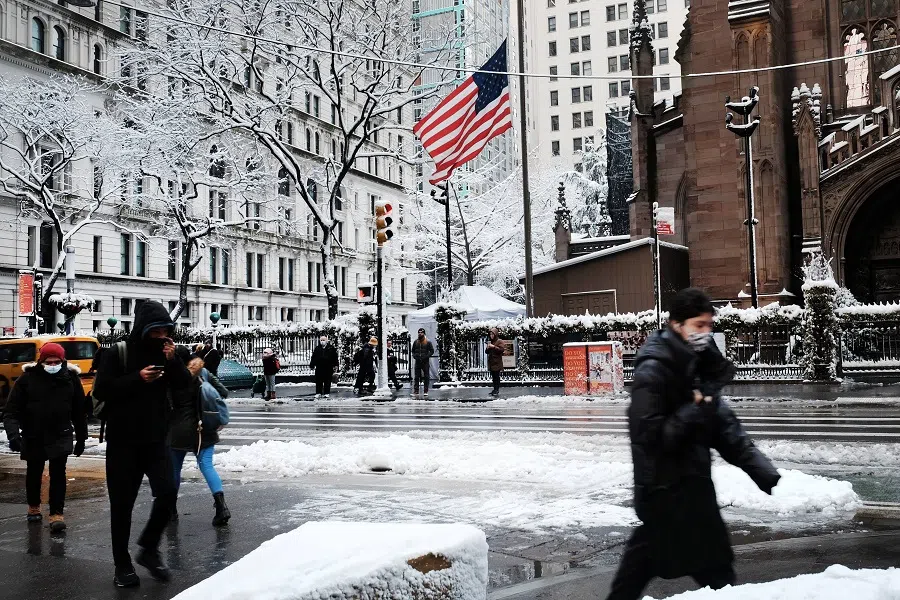 People walk through the snow in Manhattan on 7 January 2022 in New York City, US. (Spencer Platt/Getty Images/AFP)