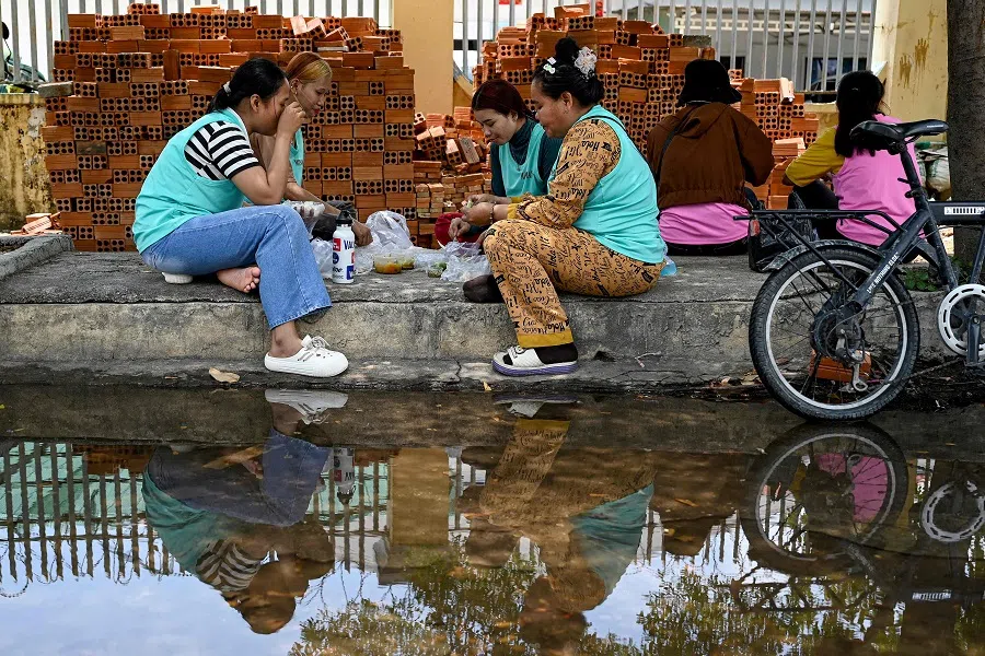 Garment workers have lunch outside their factory in Phnom Penh, Cambodia, on 3 April 2025. (Tang Chhin Sothy/AFP)