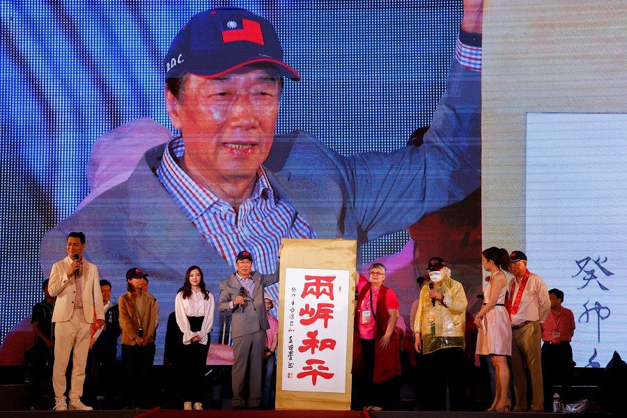 Terry Gou, the founder of major Apple supplier Foxconn and a contender to be Taiwan's next president, holds a banner during a campaign rally in New Taipei City, Taiwan, 12 May 2023. The banner reads: "Cross-strait peace". (Ann Wang/Reuters)