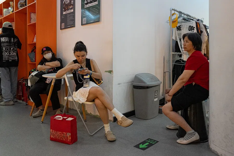 Zhuangzhuang’s mother (left) and other mums wait outside the classroom for their kids.