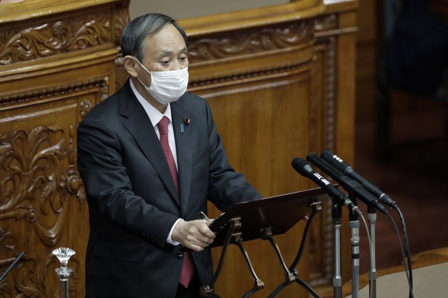 Yoshihide Suga, Japan's prime minister, wears a protective face mask as he speaks during a plenary session at the upper house of parliament in Tokyo, Japan, on 30 November 2020.(Kiyoshi Ota/Bloomberg)