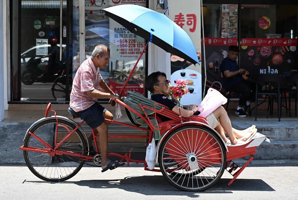This picture taken on 11 March 2023 shows people riding in a trishaw in George Town, Penang, Malaysia. (Mohd Rasfan/AFP)