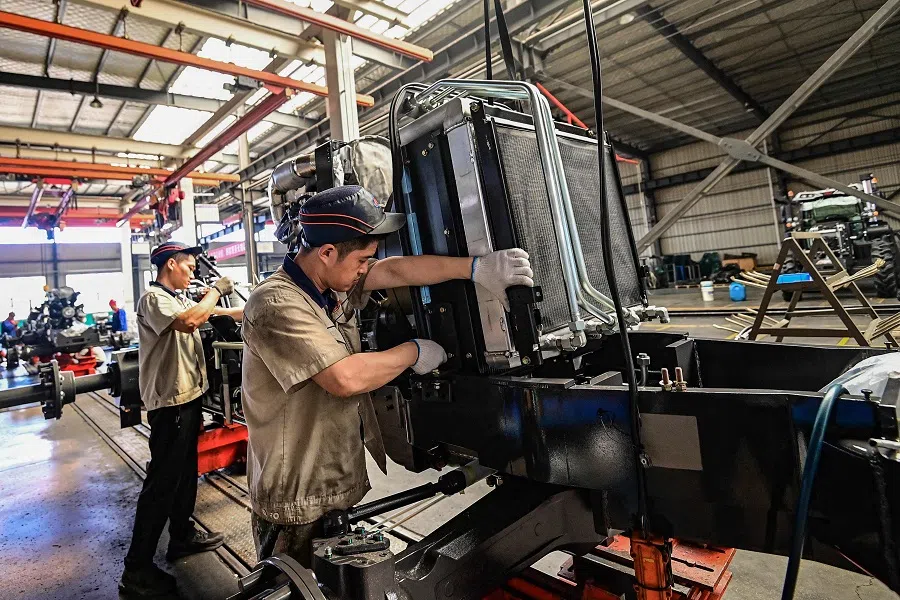 Employees work on a tractor assembly line at a factory in Qingzhou, in eastern China’s Shandong province on 27 May 2025. (AFP)