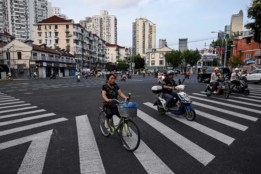 People ride bicycles and scooters in Shanghai’s Jing’an district on 26 August 2024. 